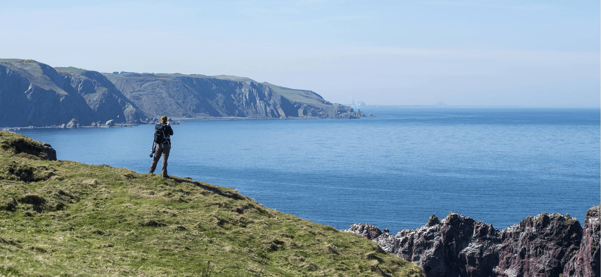 Man on cliff with binoculars